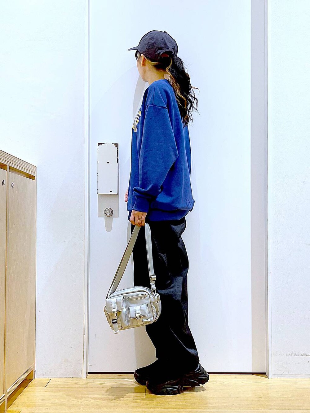 ブラック系のカーゴパンツ、ブラック系のスニーカー、ブルー系のスウェットを着用したレディースの冬コーディネートの3枚目の写真