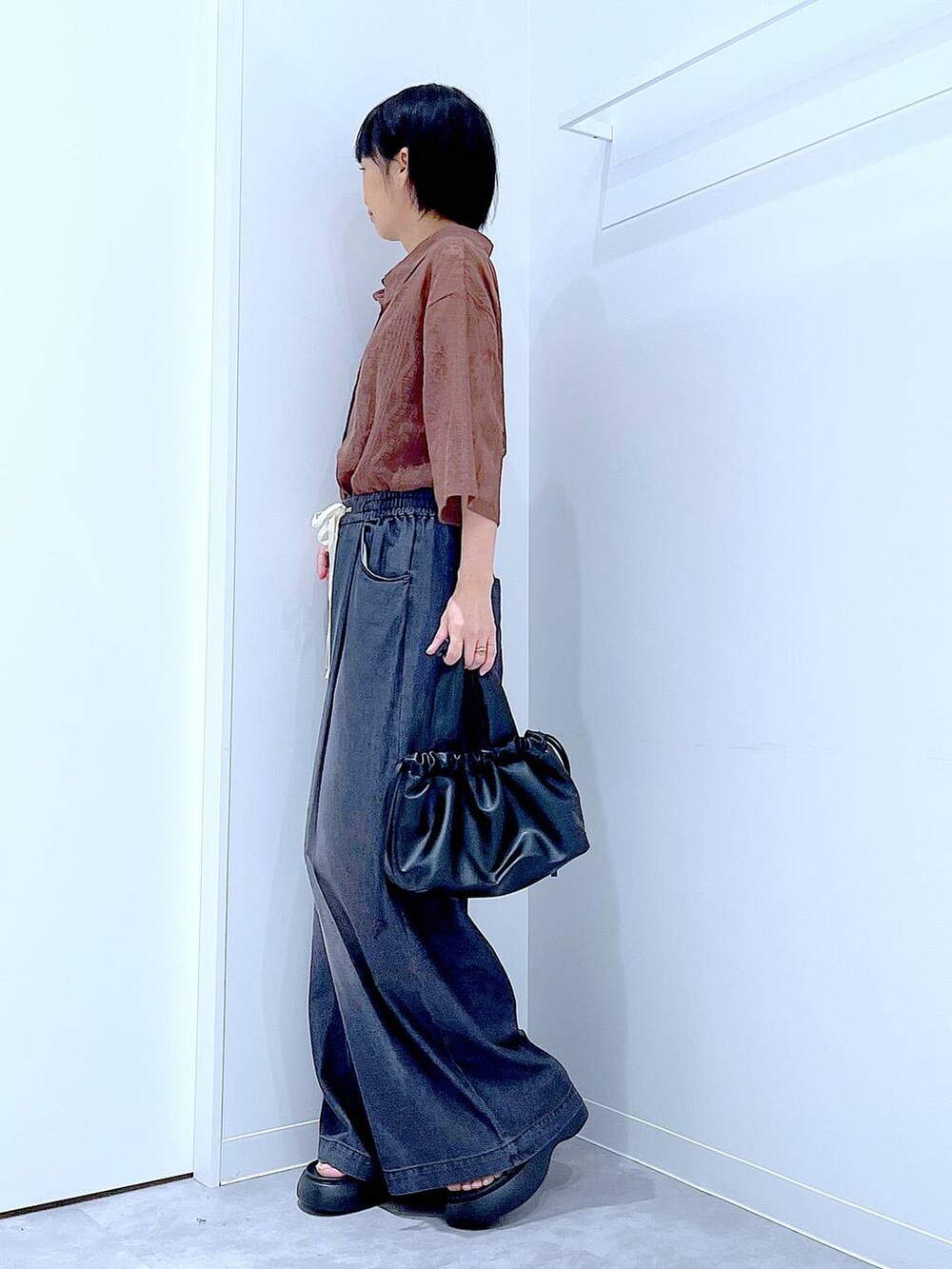 ブラウン系のシャツ/ブラウス、ブラック系のショルダーバッグ、ブラック系のデニムパンツを着用したレディースの夏コーディネートの3枚目の写真