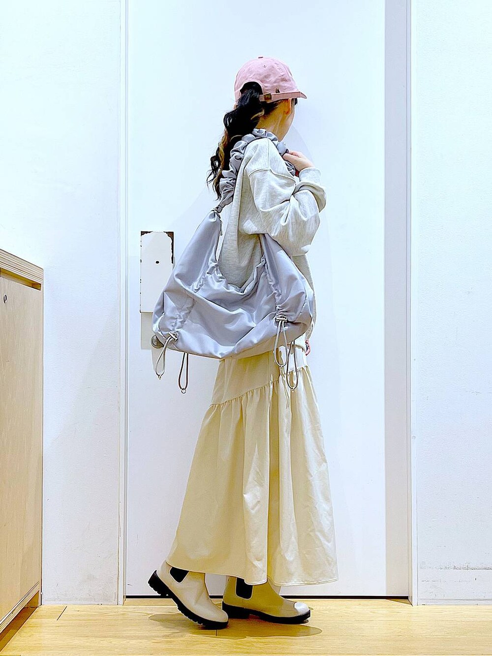 ベージュ系のスウェット、ホワイト系のスカート、ベージュ系のブーツを着用したレディースの春コーディネートの4枚目の写真