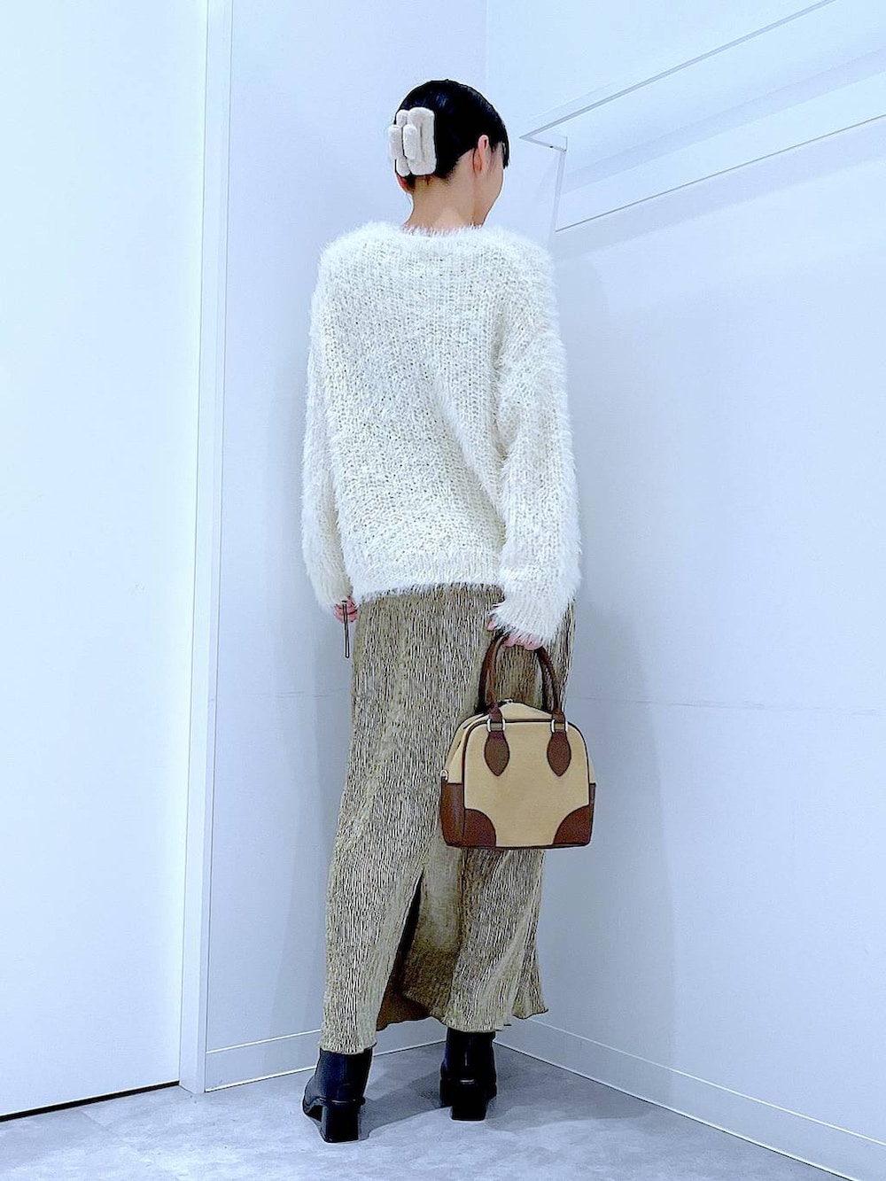 ベージュ系のハンドバッグ、ブラック系のブーツ、ベージュ系のニット/セーターを着用したレディースの冬コーディネートの5枚目の写真