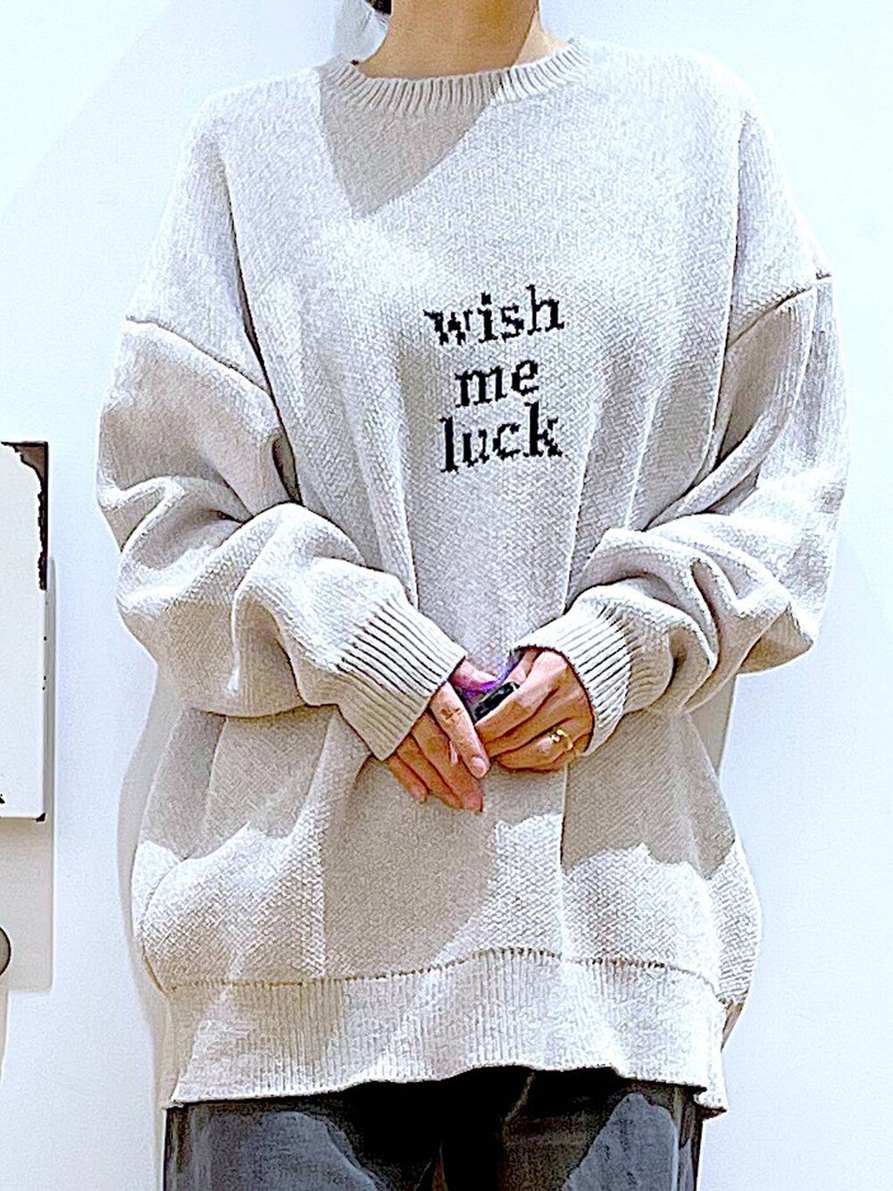 ブラック系のブーツ、ベージュ系のニット/セーター、ブルー系のデニムパンツを着用したレディースの冬コーディネートの7枚目の写真