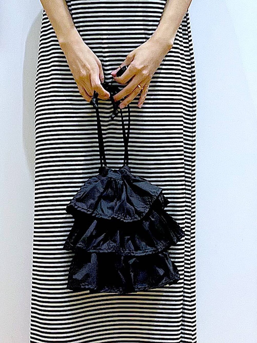 ブラック系のショルダーバッグ、ブラック系のサンダル、ブラック系のワンピースを着用したレディースの夏コーディネートの9枚目の写真