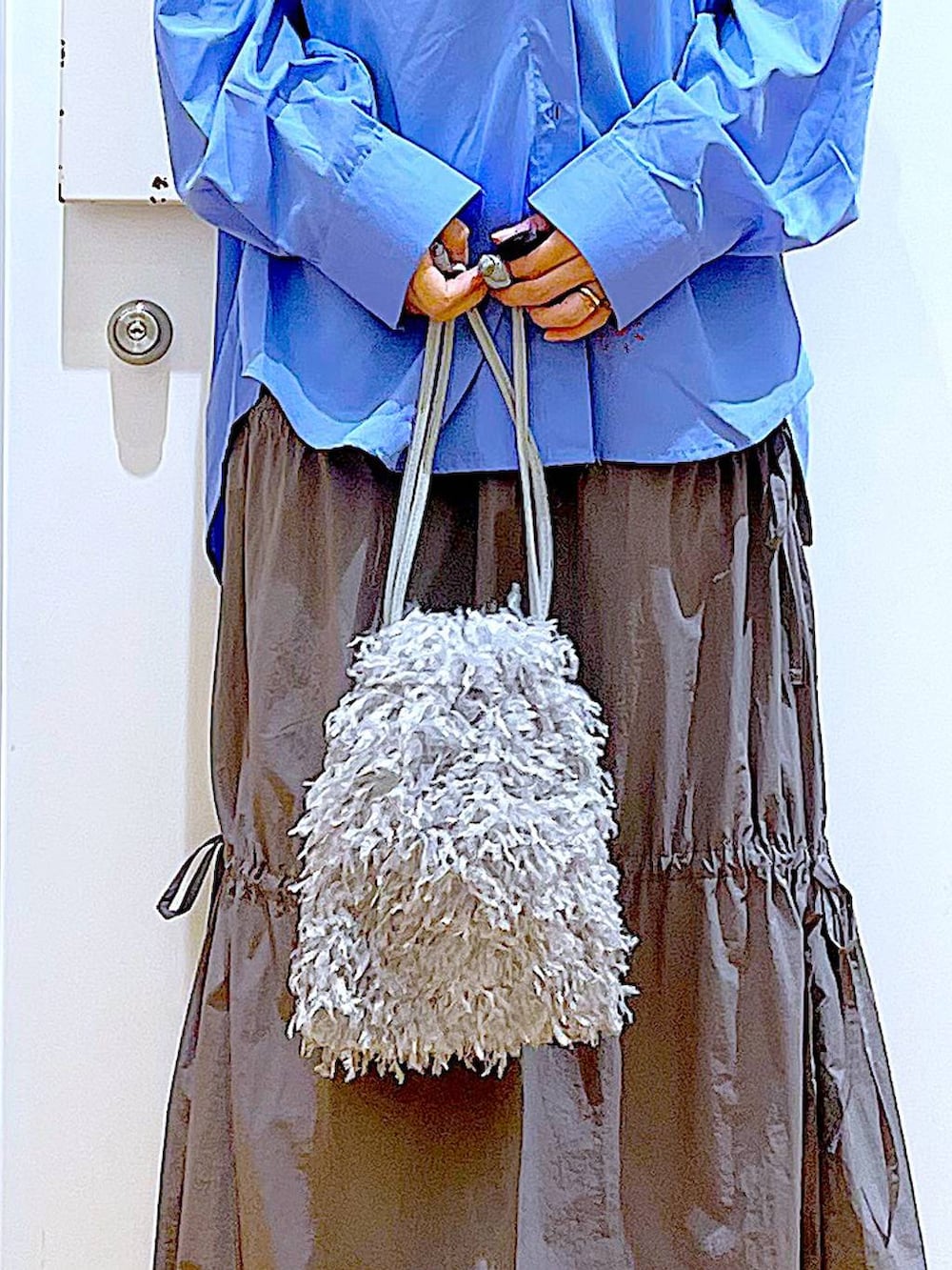 グレー系のショルダーバッグ、シルバー系のパンプス、グレー系のスカートを着用したレディースの秋コーディネートの9枚目の写真