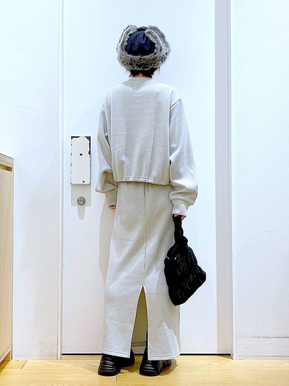 ブラック系のブーツ、ブラック系のショルダーバッグ、ベージュ系のスウェットを着用したレディースの冬コーディネートの5枚目の写真