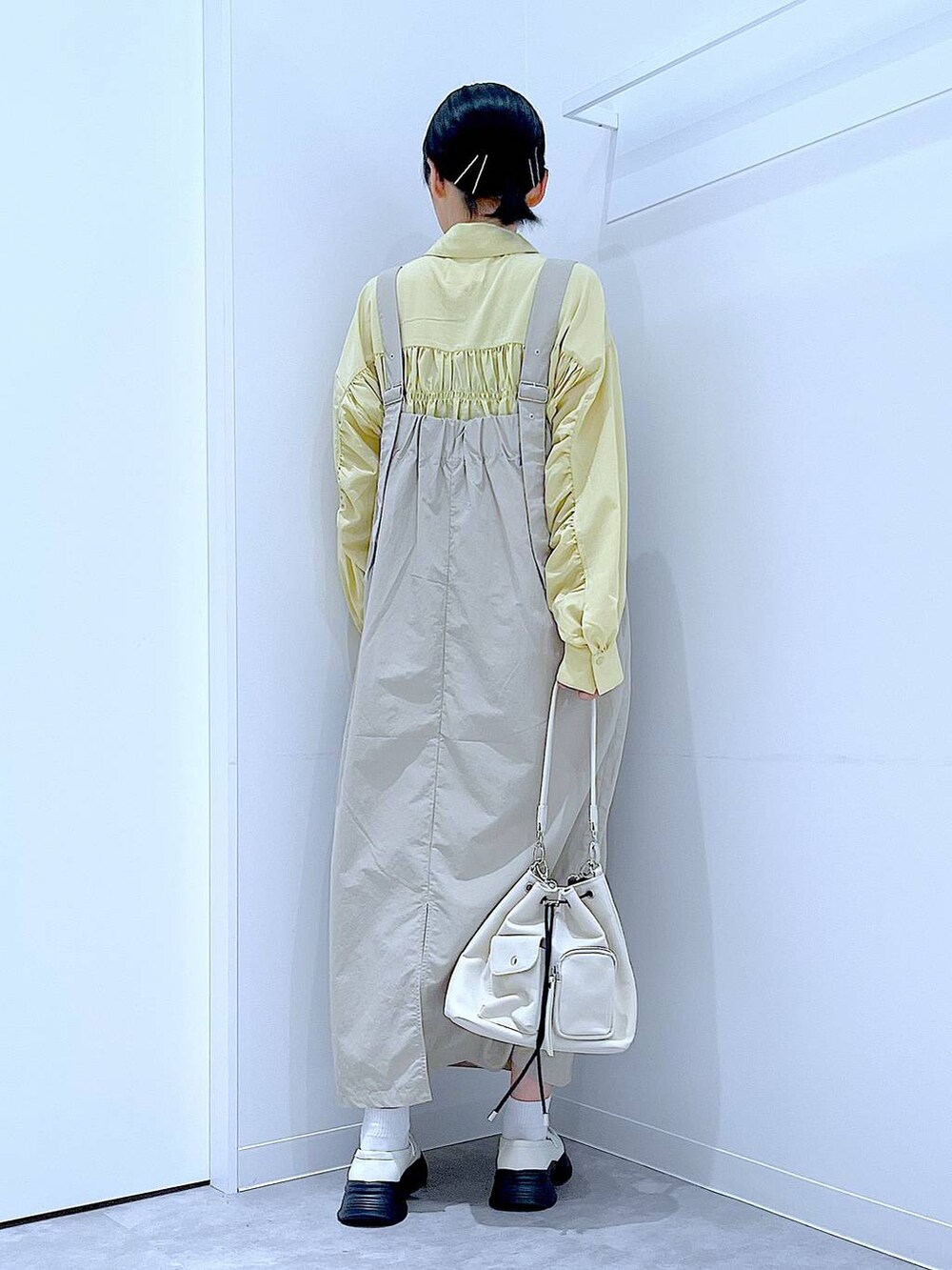 ホワイト系のローファー、ホワイト系のショルダーバッグ、グレー系のワンピースを着用したレディースの秋コーディネートの5枚目の写真