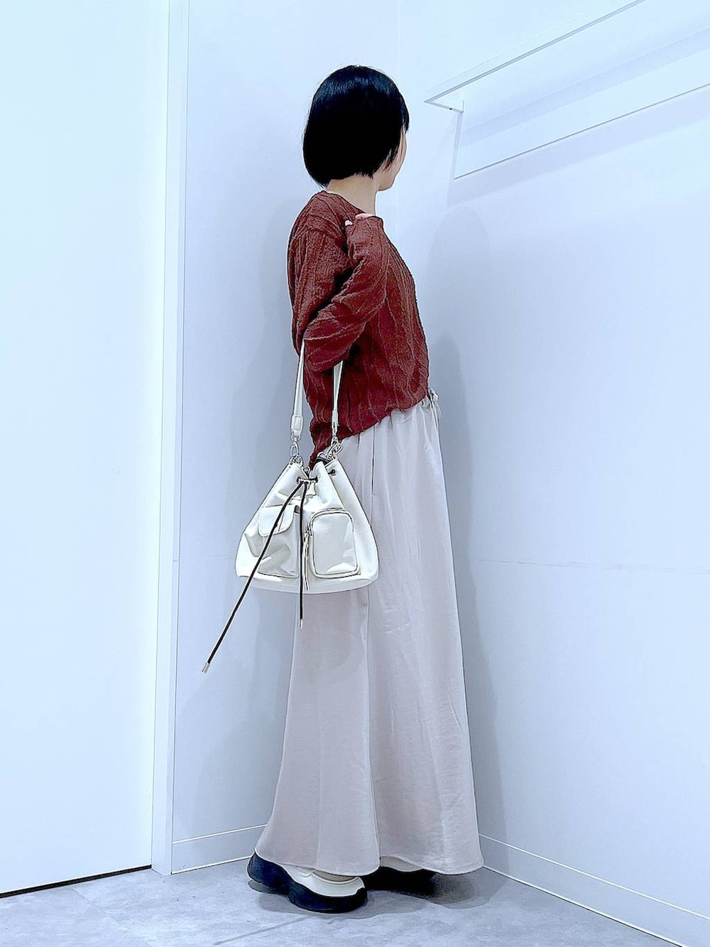 ホワイト系のローファー、ホワイト系のショルダーバッグ、ベージュ系のスカートを着用したレディースの秋コーディネートの4枚目の写真