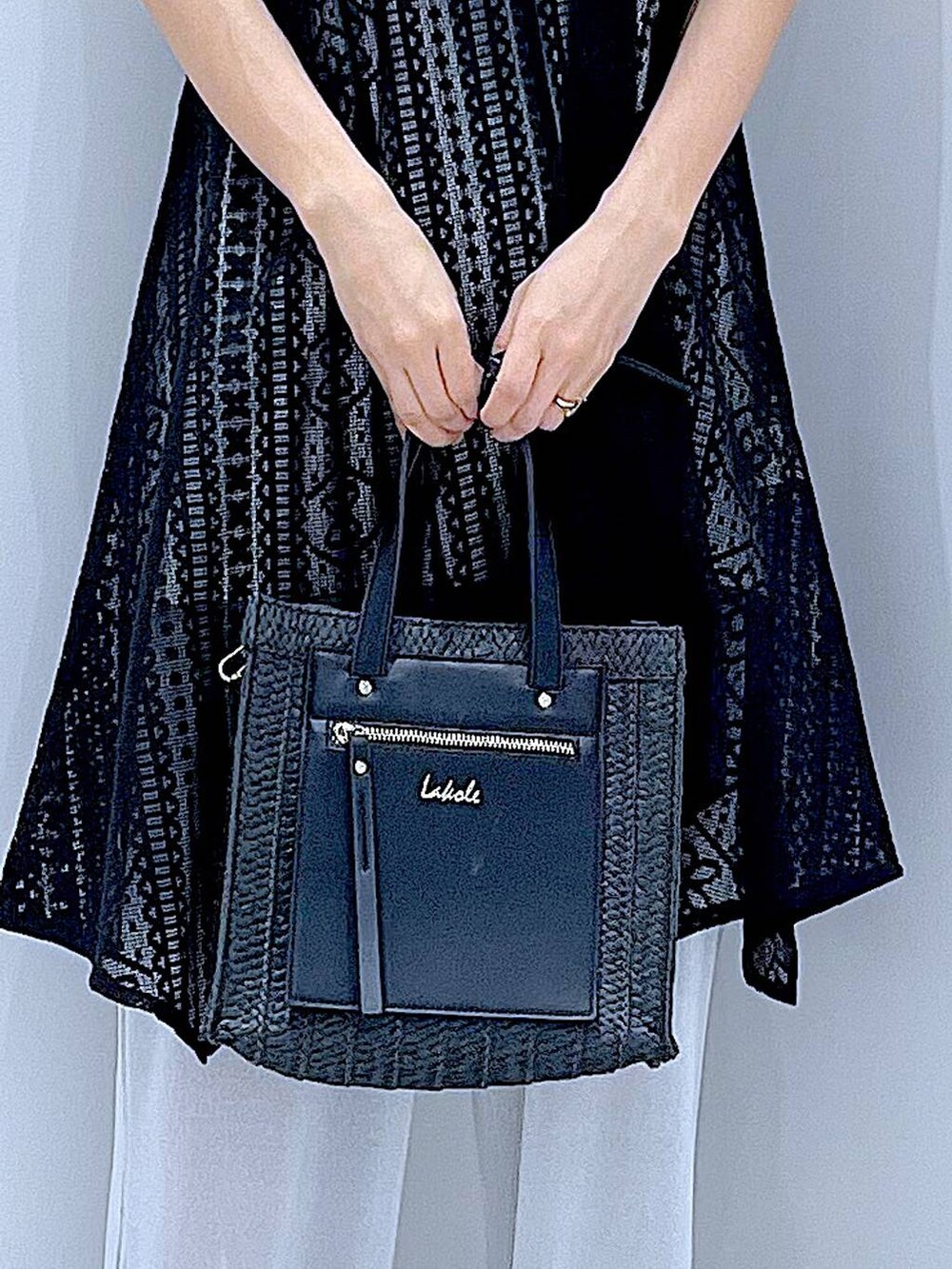 ブラック系のショルダーバッグ、ブラック系のサンダル、ホワイト系のTシャツ/カットソーを着用したレディースの夏コーディネートの9枚目の写真