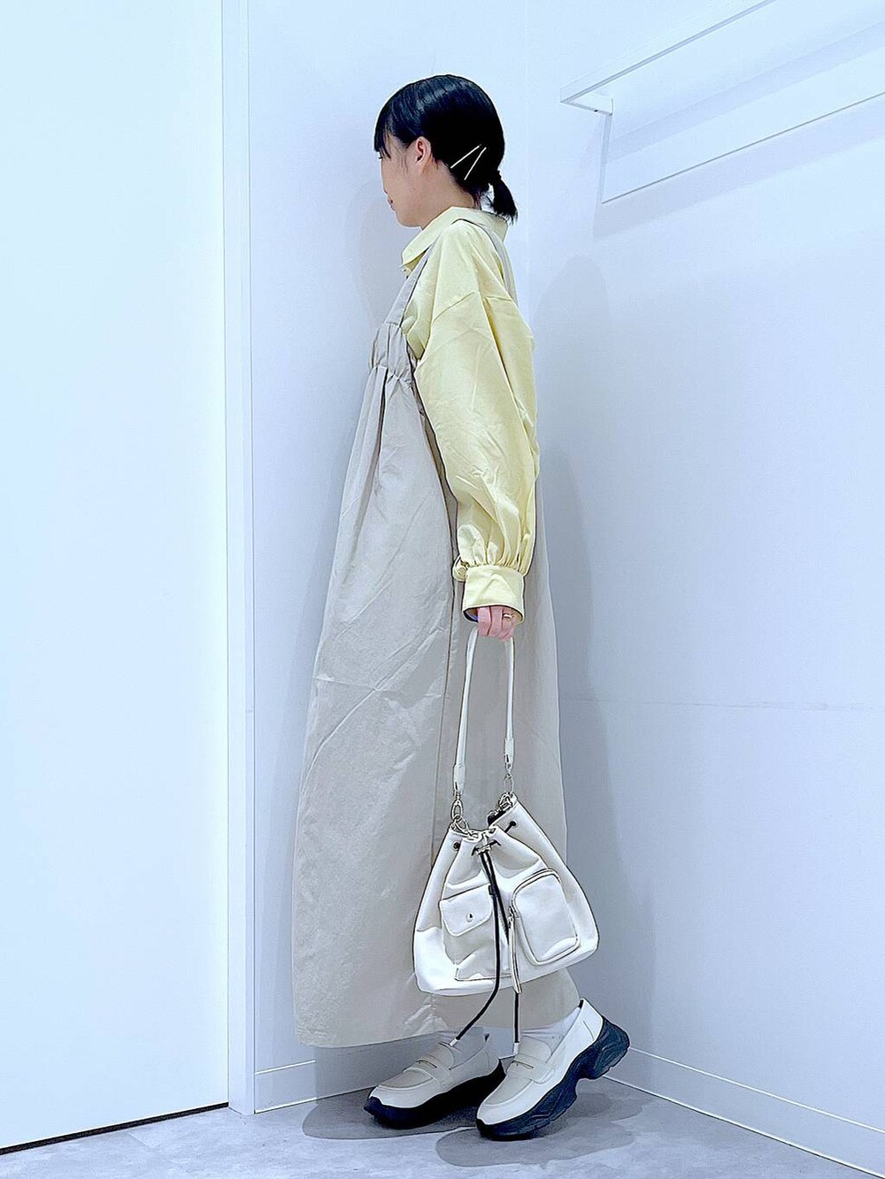 ホワイト系のローファー、ホワイト系のショルダーバッグ、グレー系のワンピースを着用したレディースの秋コーディネートの3枚目の写真