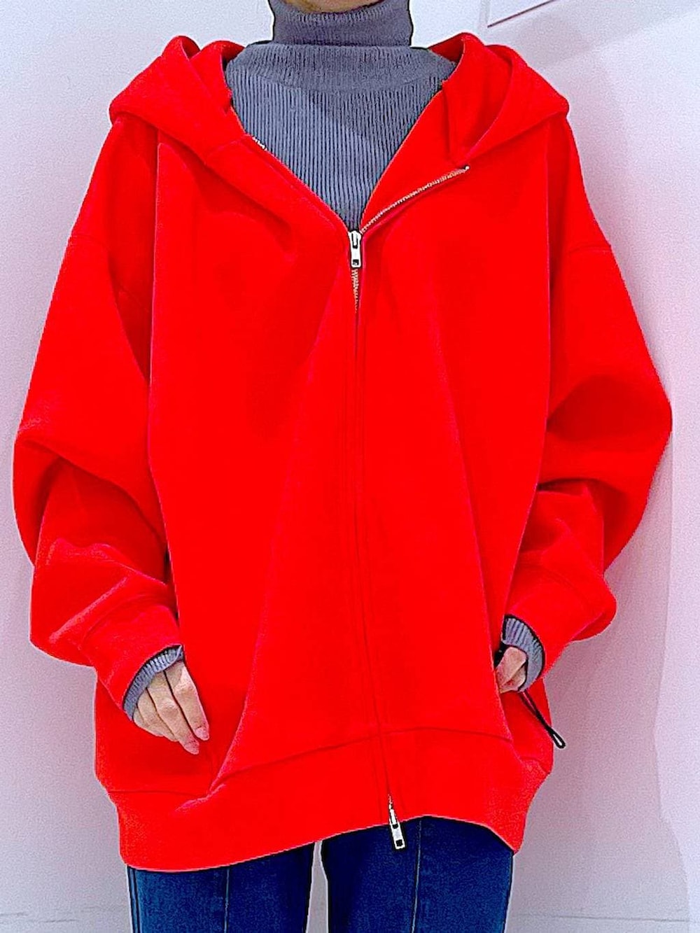 レッド系のパーカー、ブラック系のブーツ、グレー系のニット/セーターを着用したレディースの冬コーディネートの7枚目の写真