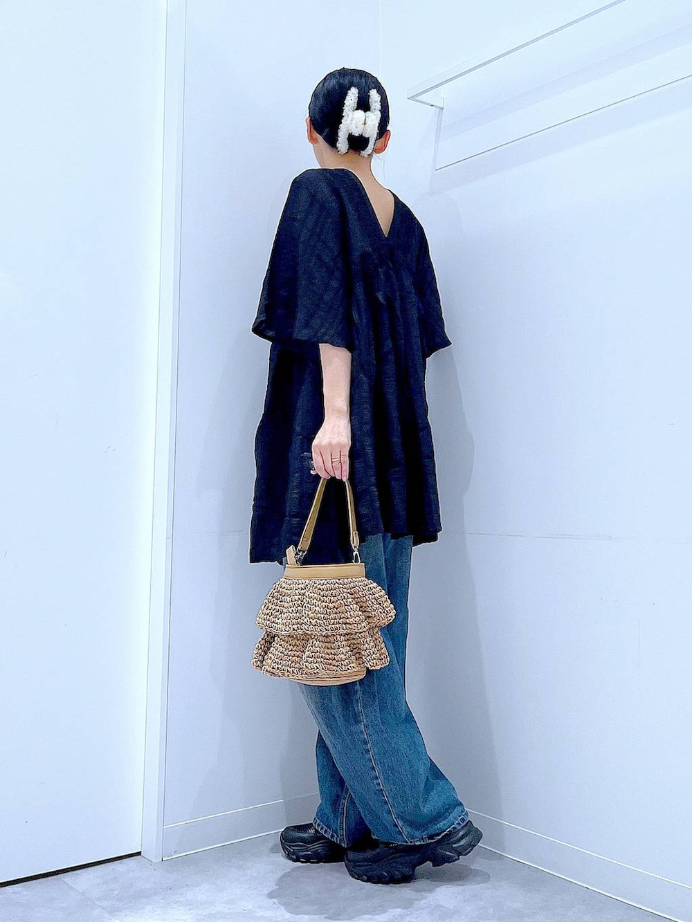 ブルー系のデニムパンツ、ブラック系のスニーカー、ベージュ系のショルダーバッグを着用したレディースの春コーディネートの3枚目の写真
