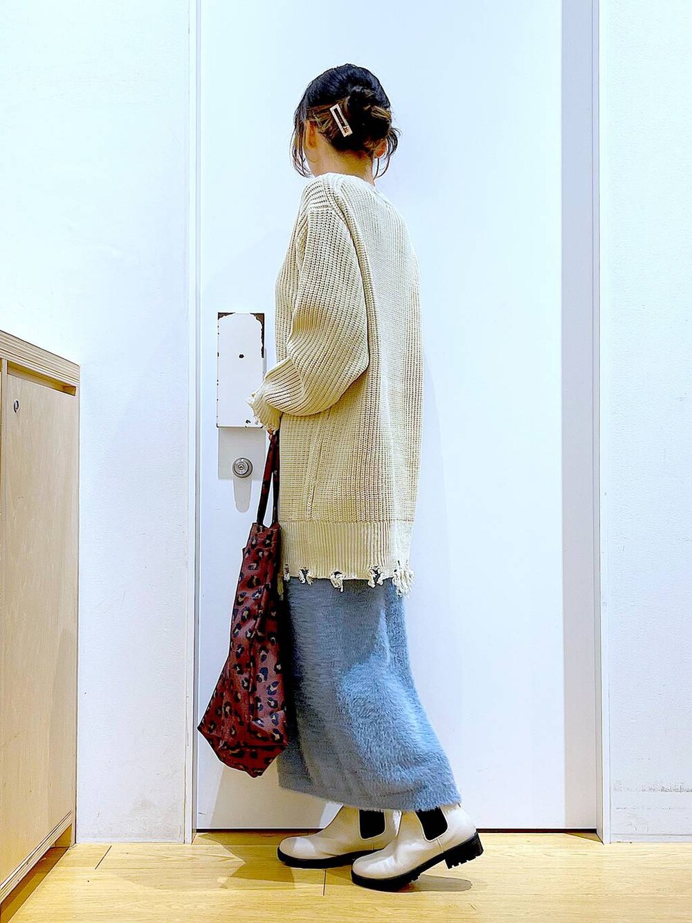 ベージュ系のブーツ、その他のトートバッグ、ブルー系のスカートを着用したレディースの冬コーディネートの3枚目の写真