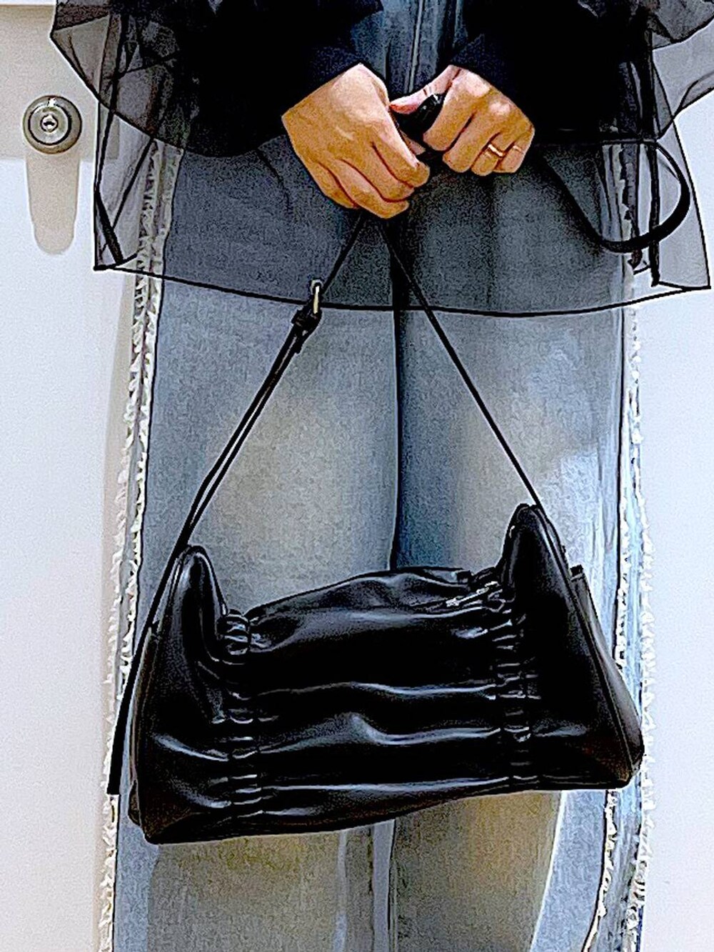 ブラック系のショルダーバッグ、ブラック系のパンプス、ブルー系のデニムパンツを着用したレディースの春コーディネートの9枚目の写真