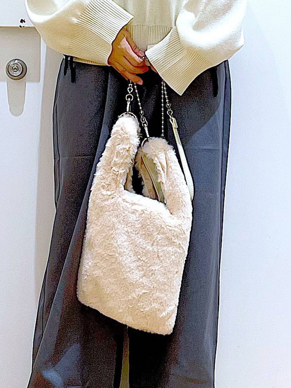 ホワイト系のショルダーバッグ、ブラック系のブーツ、グレー系のその他パンツを着用したレディースの冬コーディネートの9枚目の写真