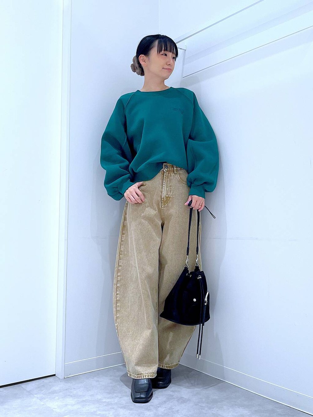 ベージュ系のデニムパンツ、ブラック系のショルダーバッグ、ブラック系のブーツを着用したレディースの冬コーディネートの2枚目の写真