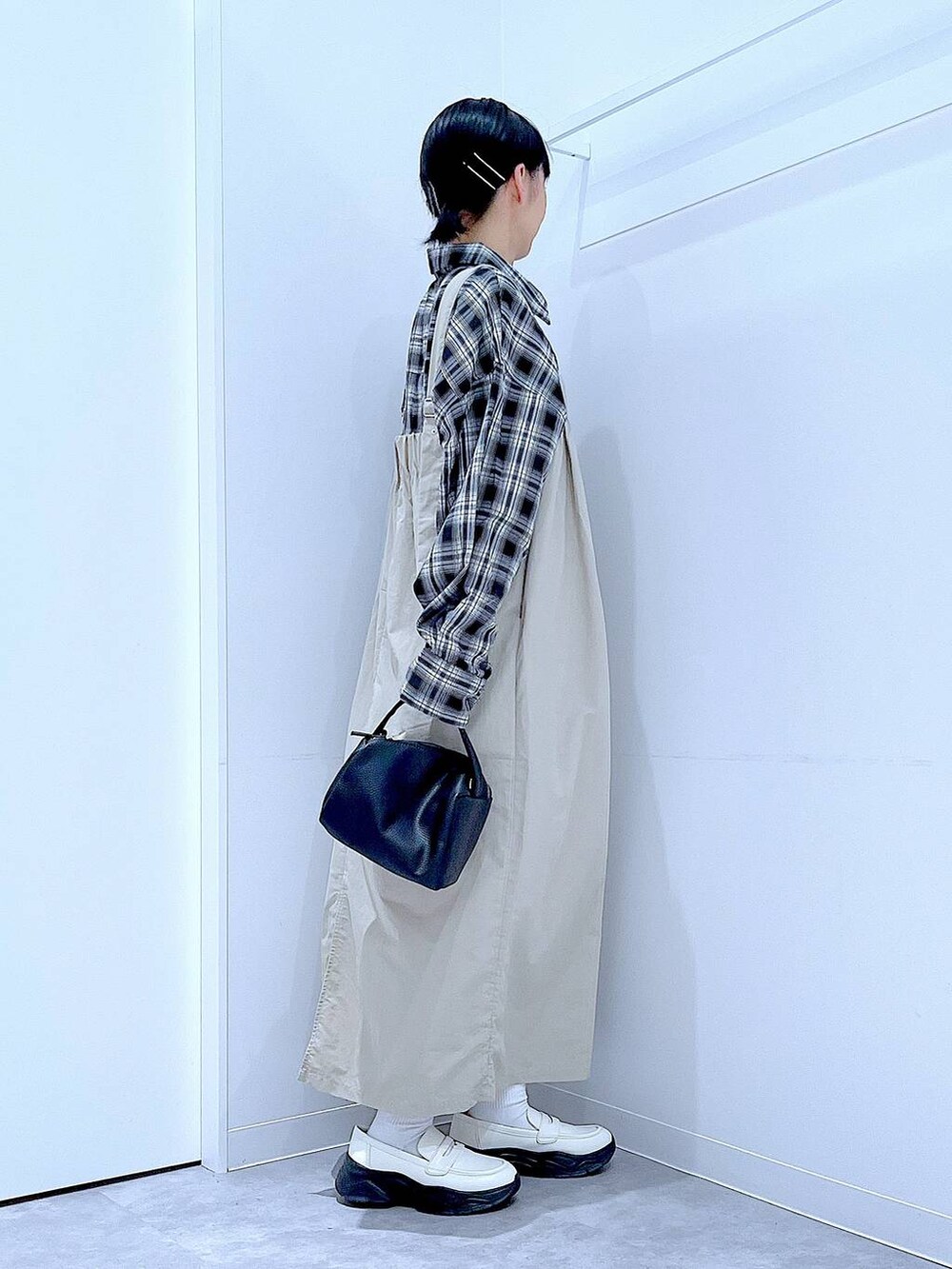 ホワイト系のローファー、ブラック系のショルダーバッグ、グレー系のワンピースを着用したレディースの秋コーディネートの4枚目の写真