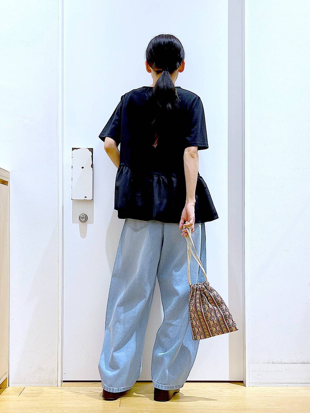 ピンク系のショルダーバッグ、ブルー系のデニムパンツ、ブラック系のTシャツ/カットソーを着用したレディースの夏コーディネートの5枚目の写真