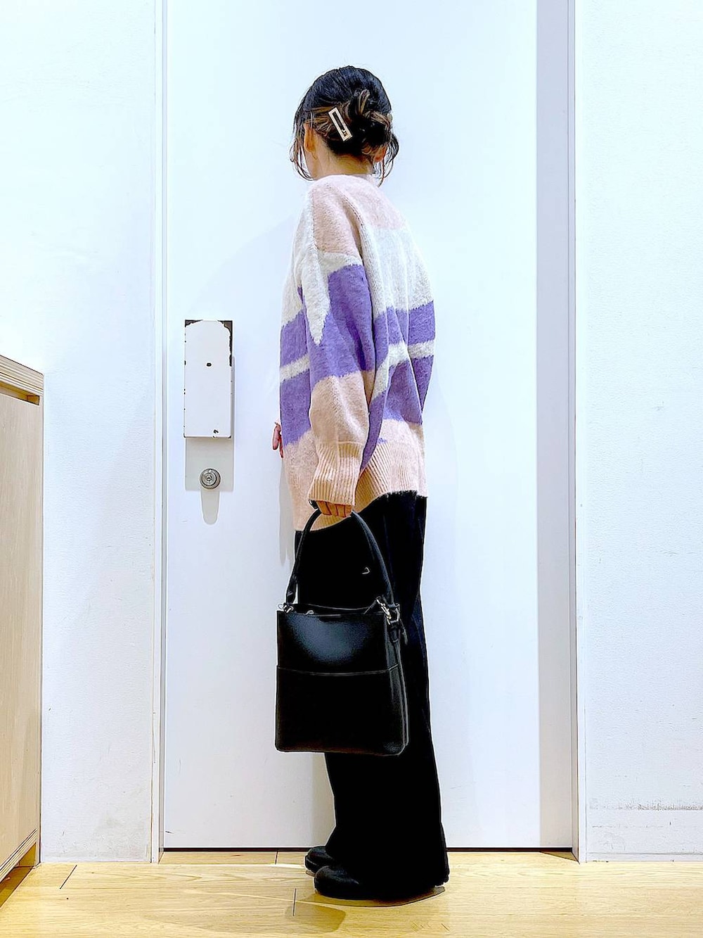 ブラック系のショルダーバッグ、ブラック系のブーツ、ブラック系のニット/セーターを着用したレディースの冬コーディネートの3枚目の写真