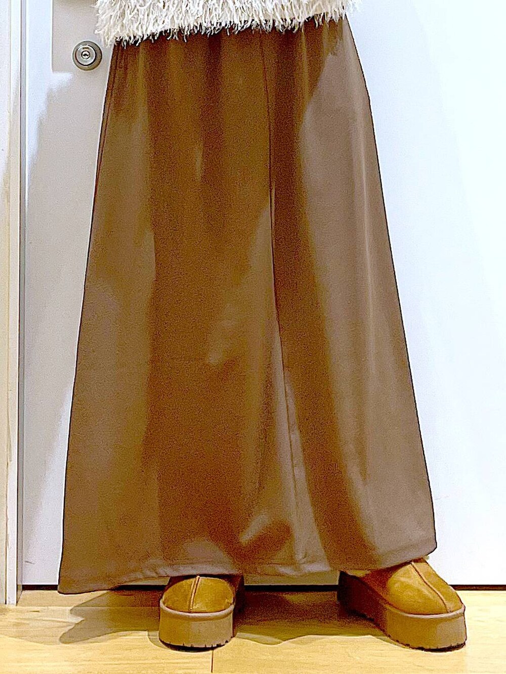 ブラック系のニット/セーター、グレー系のショルダーバッグ、ベージュ系のベストを着用したレディースの秋コーディネートの8枚目の写真