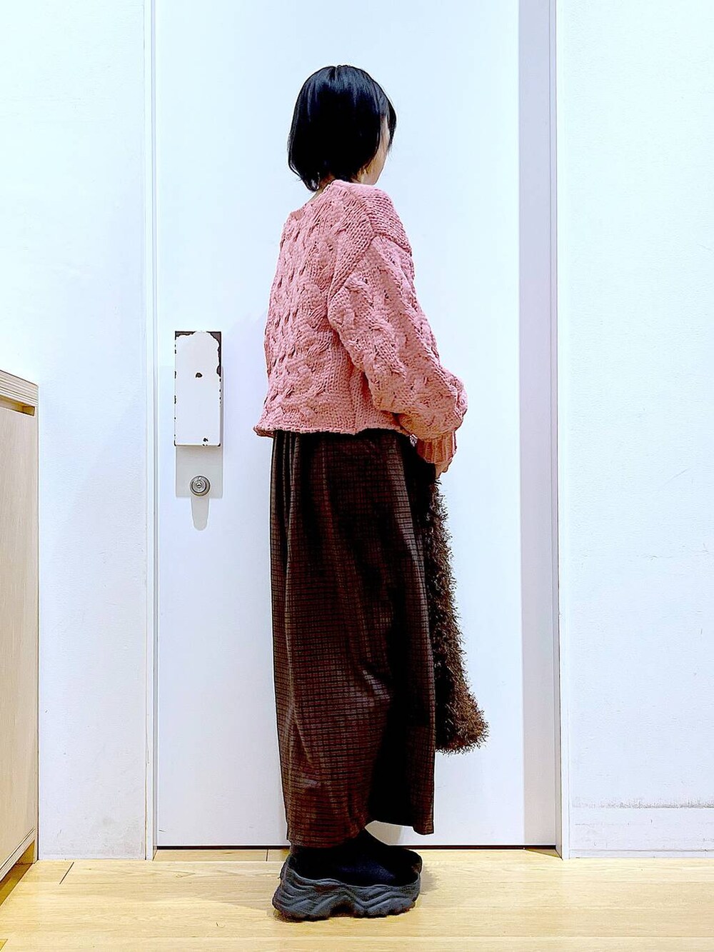 ブラック系のブーツ、ブラウン系のショルダーバッグ、ピンク系のニット/セーターを着用したレディースの冬コーディネートの4枚目の写真