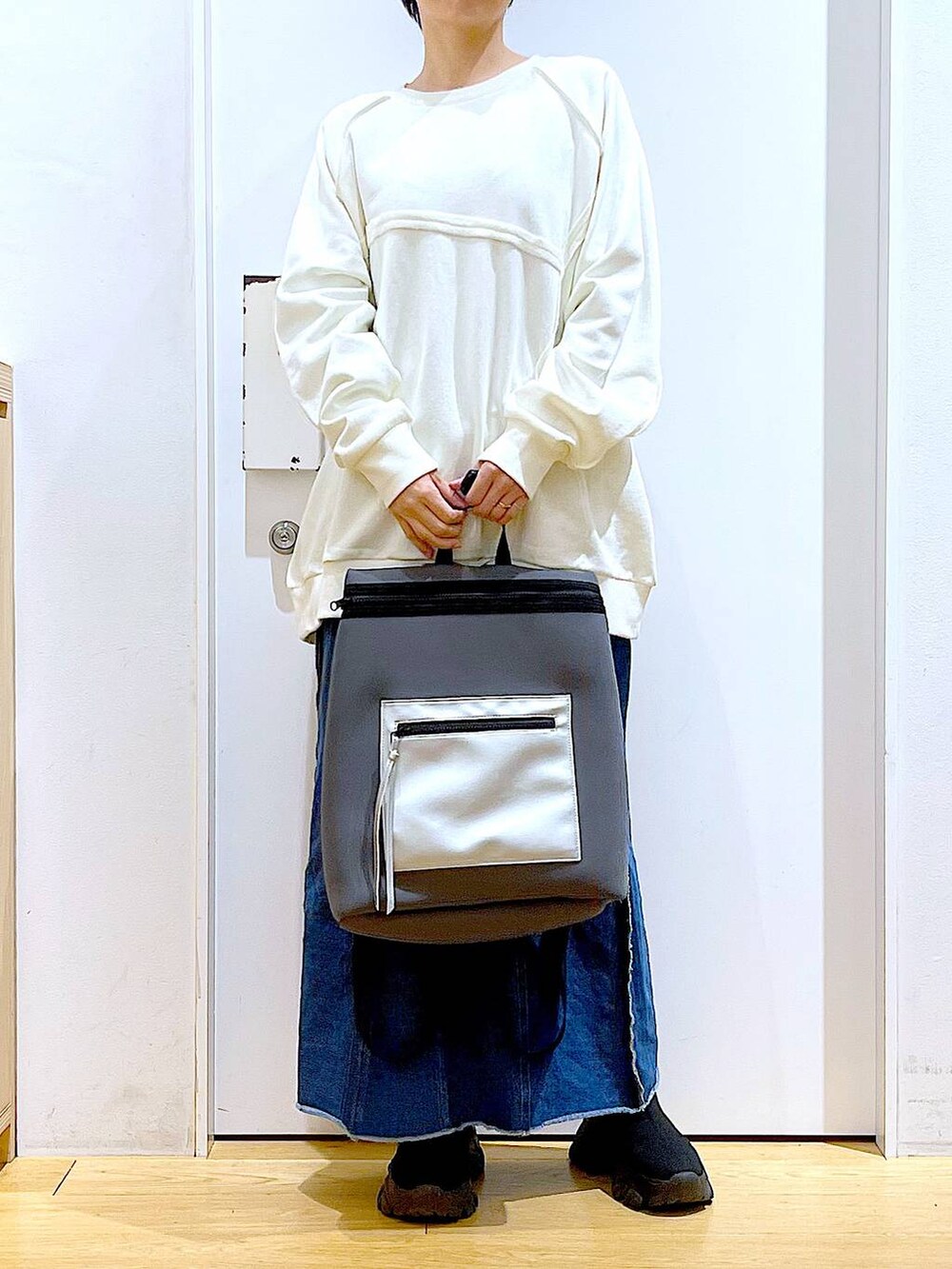 ブルー系のデニムスカート、グレー系のバックパック/リュック、ブラック系のブーツを着用したレディースの冬コーディネートの6枚目の写真