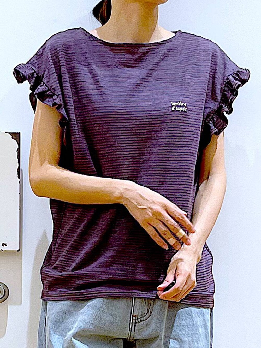 ホワイト系のショルダーバッグ、ブルー系のデニムパンツ、ホワイト系のパンプスを着用したレディースの春コーディネートの6枚目の写真