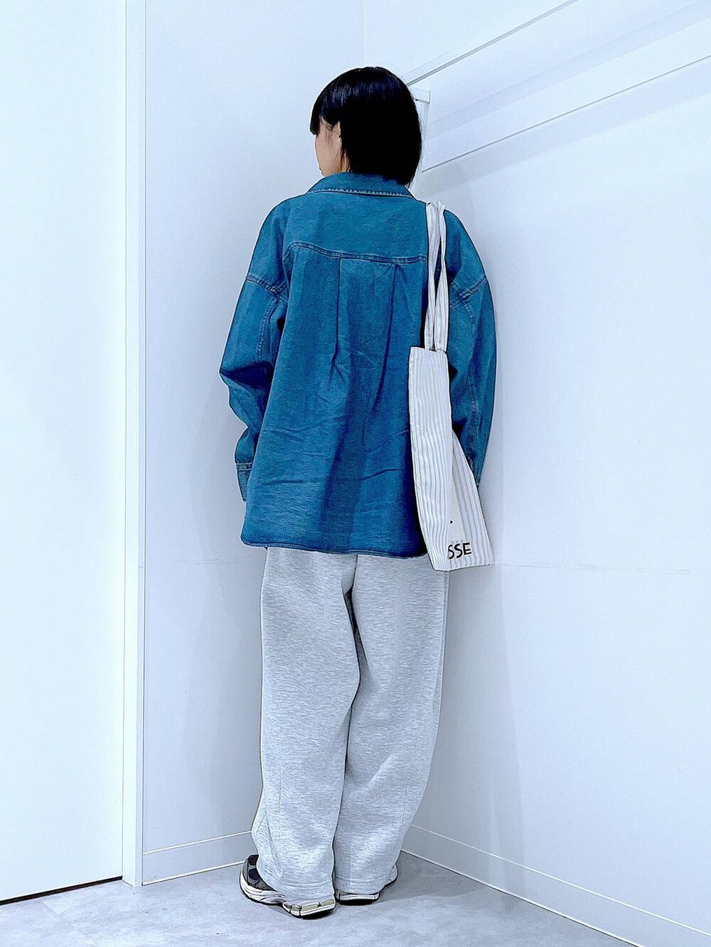 ブルー系のシャツ/ブラウス、ブラウン系のトートバッグ、グレー系のTシャツ/カットソーを着用したレディースの秋コーディネートの5枚目の写真