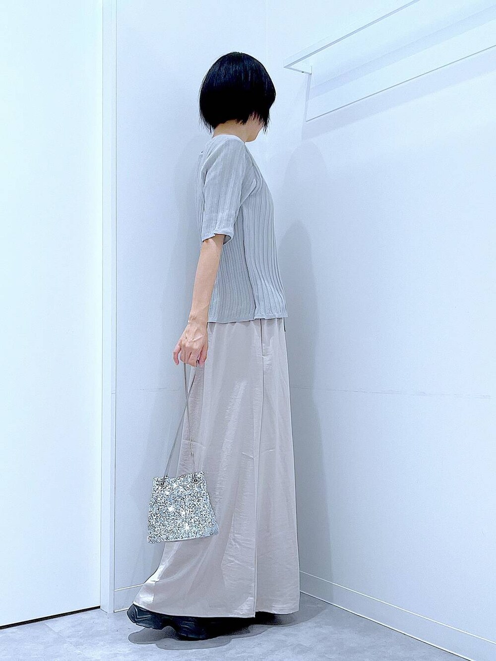 シルバー系のショルダーバッグ、ブラック系のローファー、グレー系のニット/セーターを着用したレディースの秋コーディネートの4枚目の写真