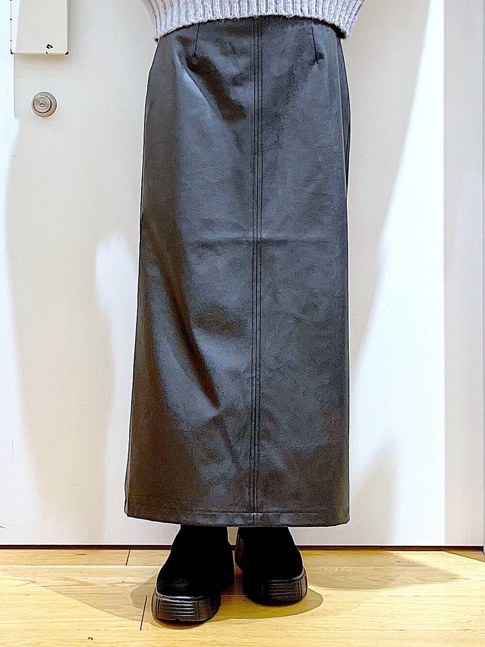 ブラック系のTシャツ/カットソー、グレー系のショルダーバッグ、ブラック系のブーツを着用したレディースの冬コーディネートの8枚目の写真