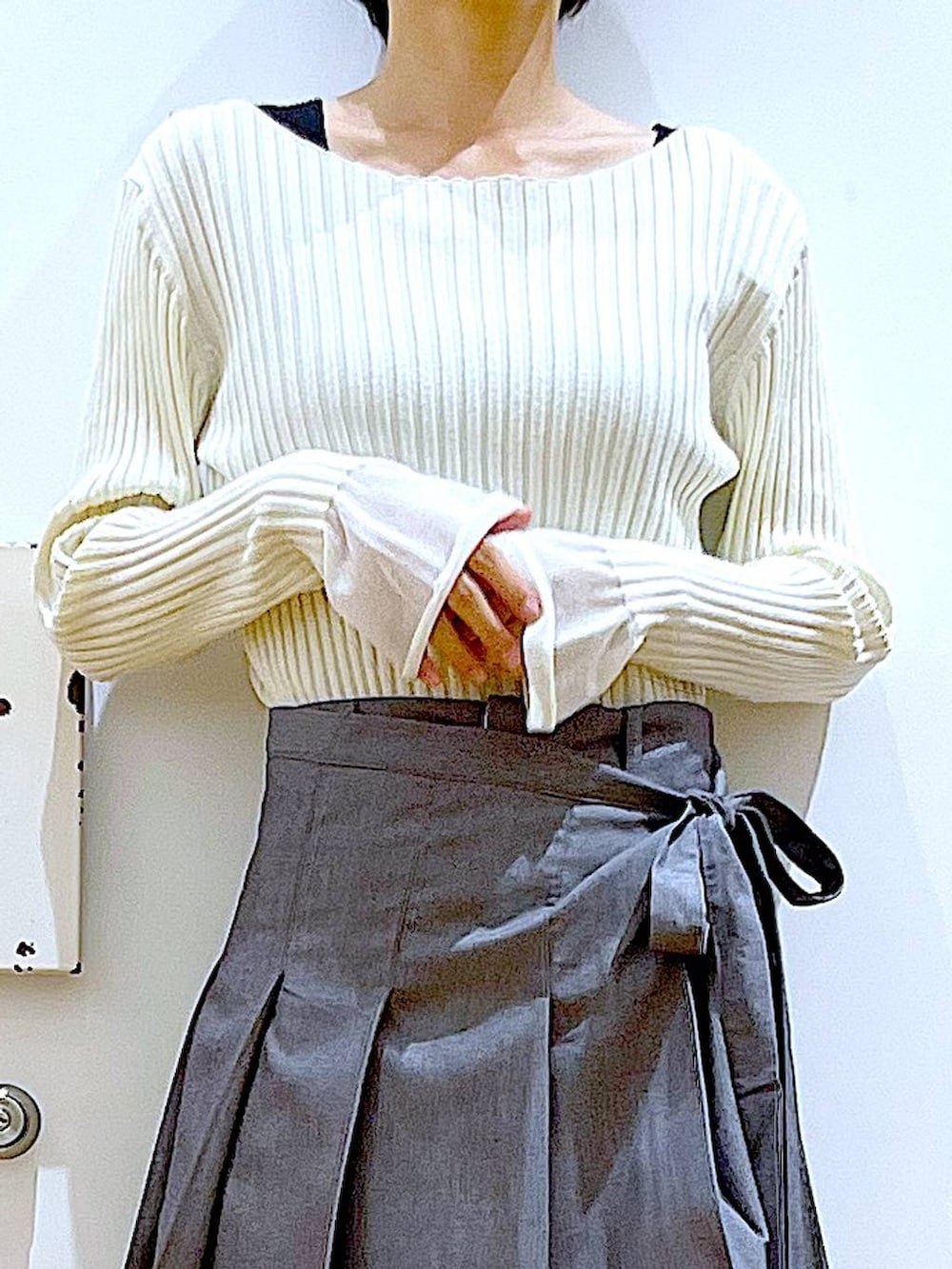 ホワイト系のニット/セーター、グレー系のスラックス、グレー系のスカートを着用したレディースの秋コーディネートの7枚目の写真