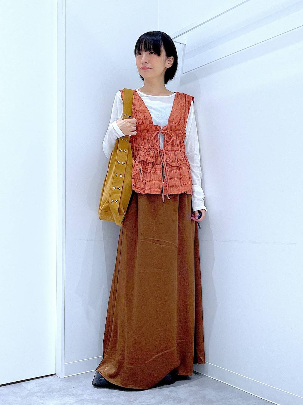 ホワイト系のTシャツ/カットソー、ブラック系のローファー、ブラウン系のスカートを着用したレディースの秋コーディネートの2枚目の写真