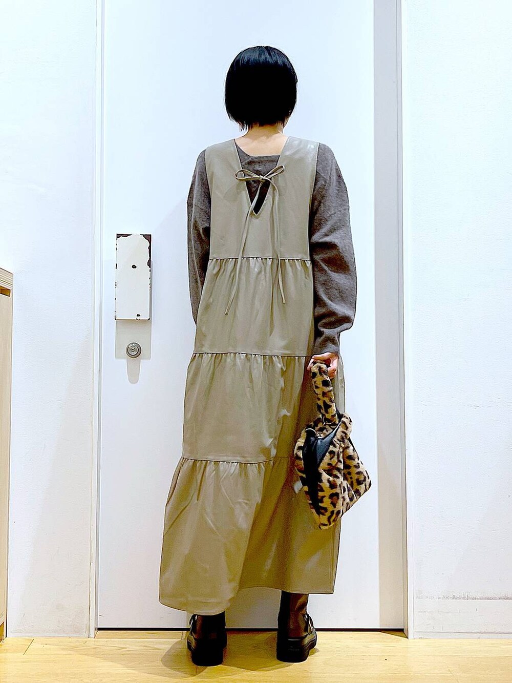 ブラウン系のニット/セーター、その他のショルダーバッグ、ブラウン系のブーツを着用したレディースの冬コーディネートの5枚目の写真