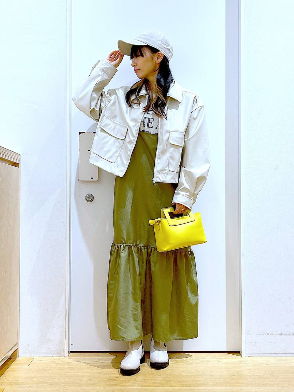 ベージュ系のブルゾン、ホワイト系のTシャツ/カットソー、ベージュ系のブーツを着用したレディースの春コーディネートの2枚目の写真