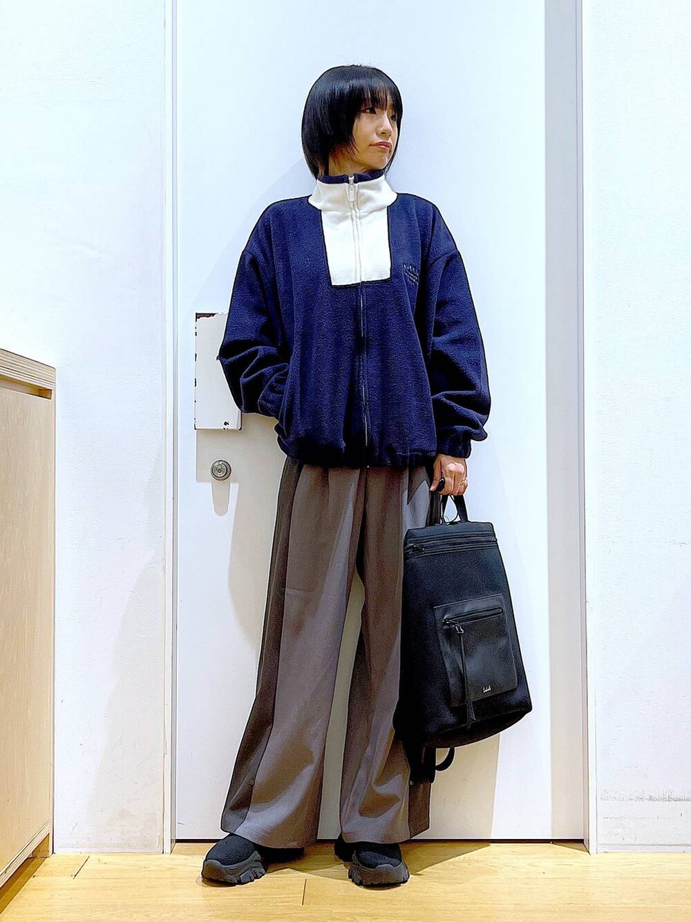 ブラック系のバックパック/リュック、ブラック系のブーツ、グレー系のその他パンツを着用したレディースの冬コーディネートの2枚目の写真