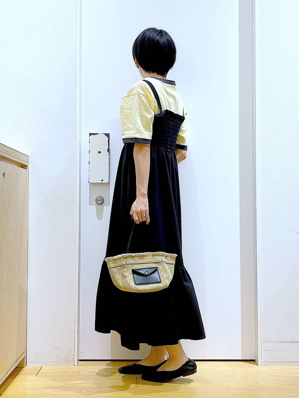 ブラック系のパンプス、ベージュ系のショルダーバッグ、ブラック系のワンピースを着用したレディースの夏コーディネートの3枚目の写真