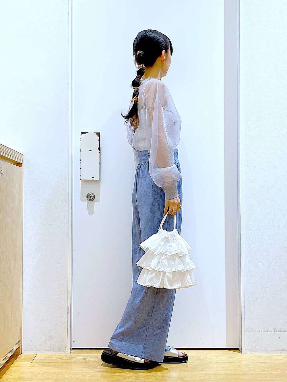 ホワイト系のショルダーバッグ、シルバー系のサンダル、グレー系のカーディガン/ボレロを着用したレディースの春コーディネートの4枚目の写真