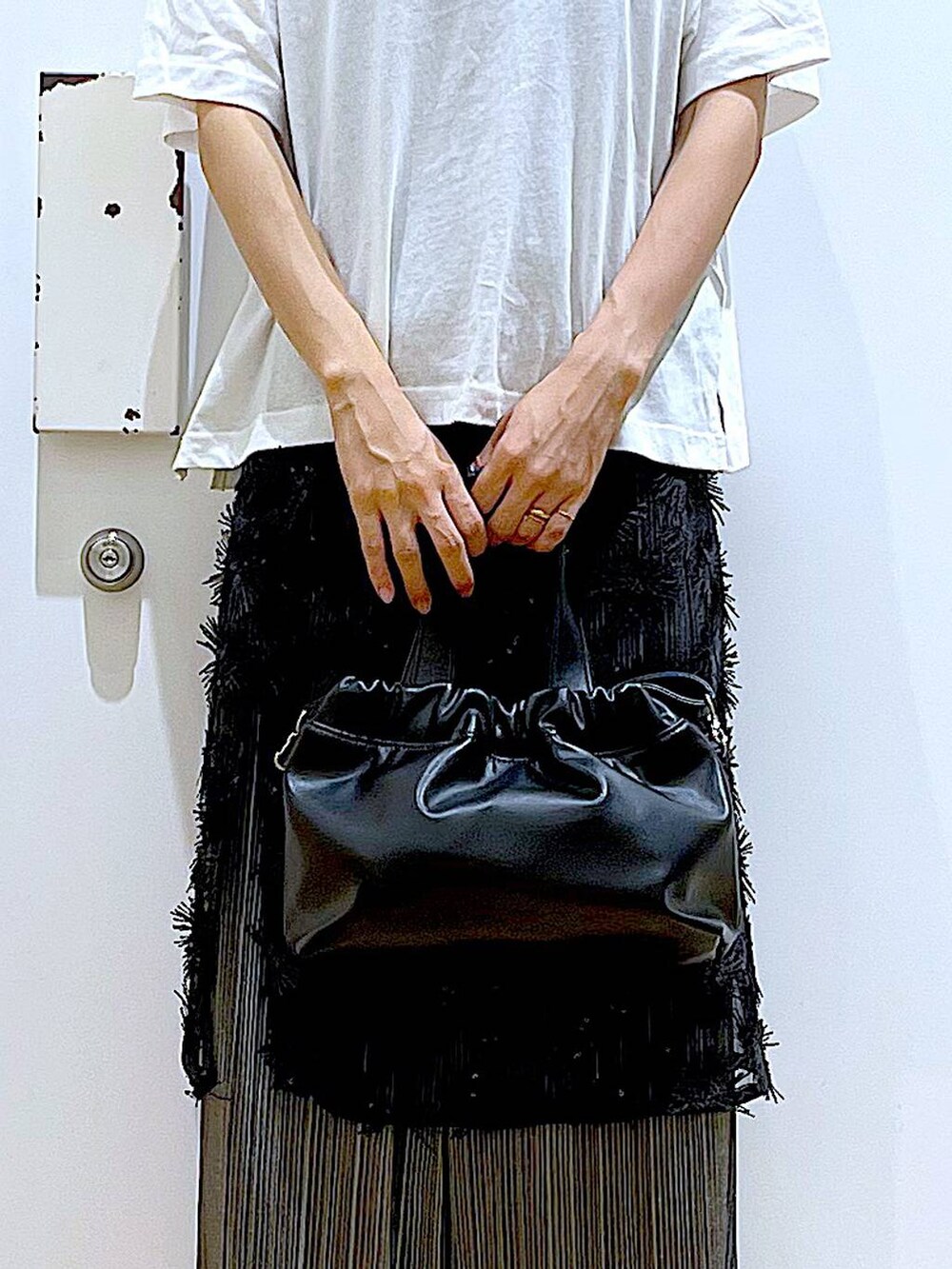 ブラック系のサンダル、ブラック系のショルダーバッグ、ブラック系のスカートを着用したレディースの秋コーディネートの9枚目の写真