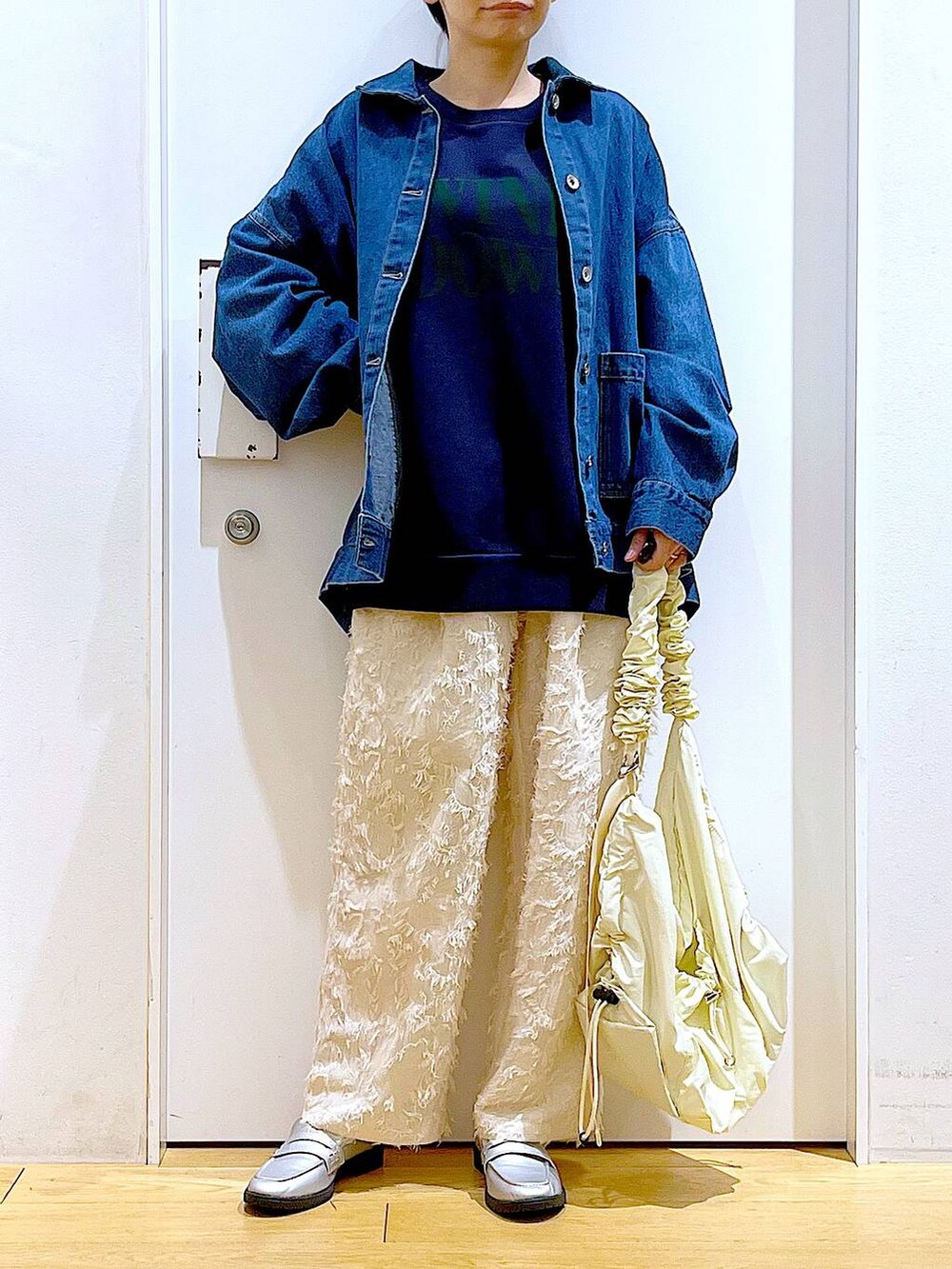 シルバー系のローファー、ブルー系のスウェット、ブルー系のデニムジャケットを着用したレディースの春コーディネートの6枚目の写真