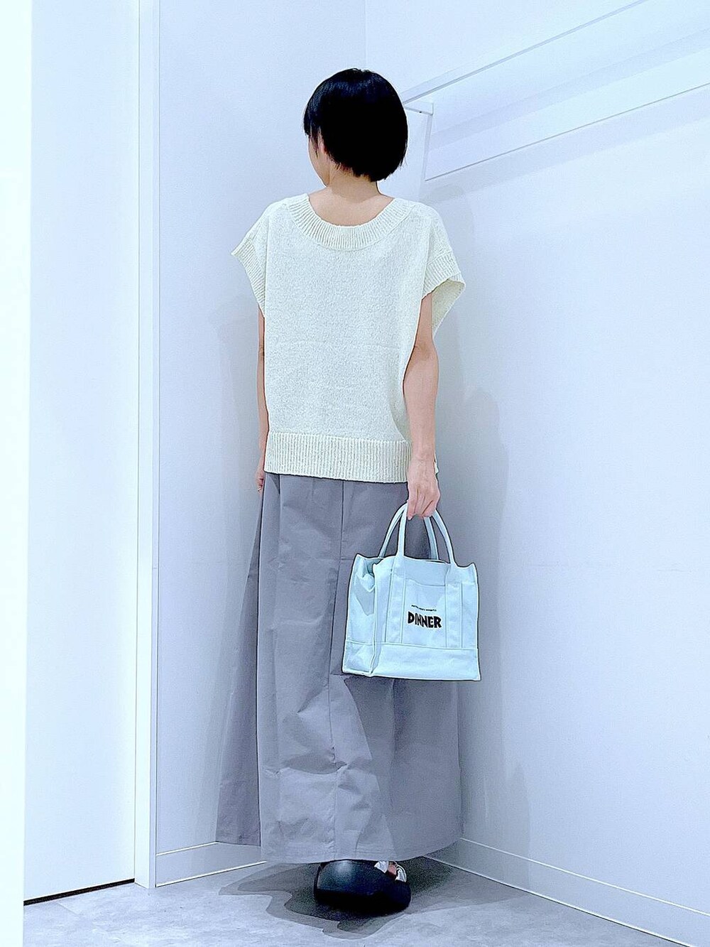 シルバー系のサンダル、グレー系のスカート、ホワイト系のベストを着用したレディースの夏コーディネートの5枚目の写真