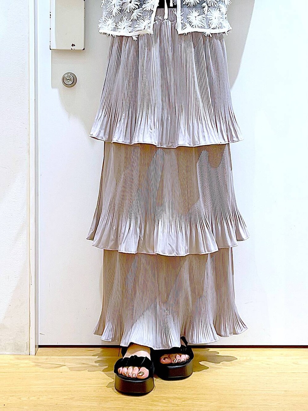 グレー系のスカート、ブラック系のサンダル、ホワイト系のショルダーバッグを着用したレディースの夏コーディネートの8枚目の写真