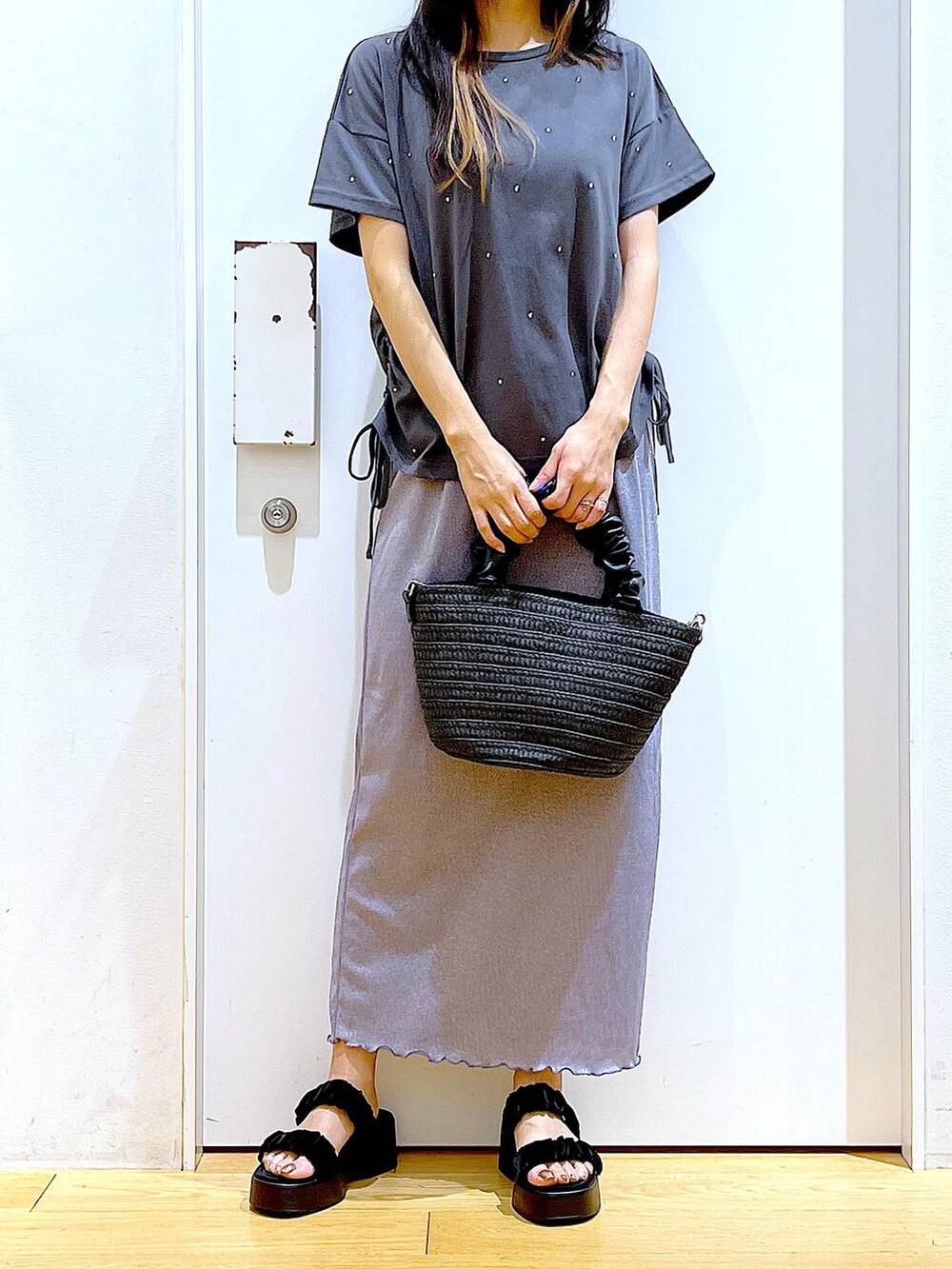 パープル系のスカート、ブラック系のショルダーバッグ、ブラック系のサンダルを着用したレディースの夏コーディネートの6枚目の写真