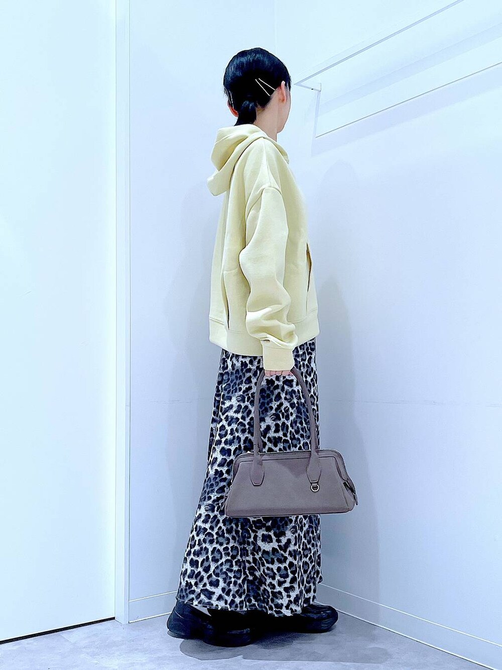 ブラック系のローファー、グレー系のスカート、イエロー系のパーカーを着用したレディースの秋コーディネートの4枚目の写真