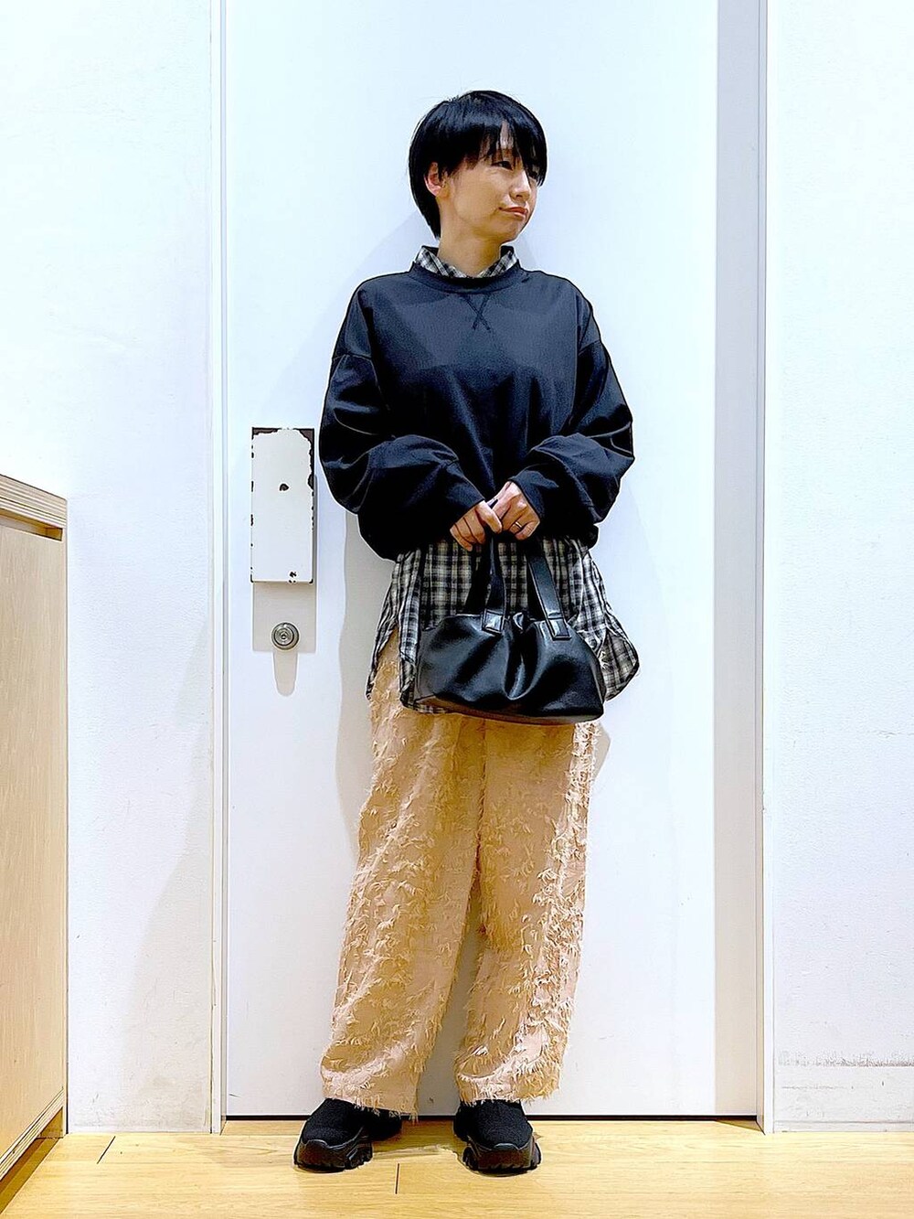 ブラック系のブーツ、ブラック系のTシャツ/カットソー、ブラック系のショルダーバッグを着用したレディースの冬コーディネートの2枚目の写真