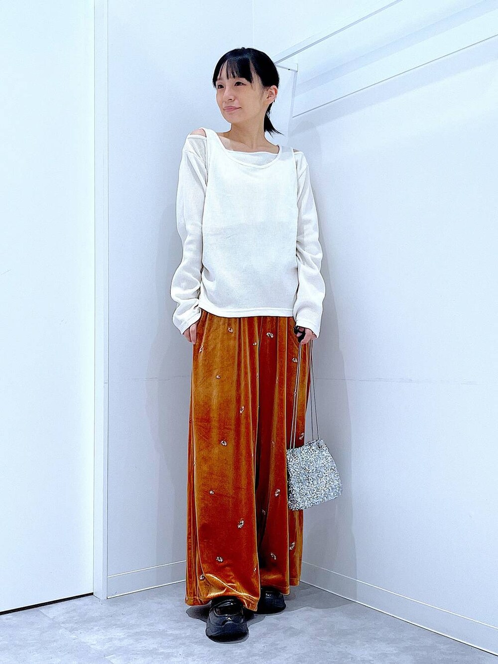 シルバー系のショルダーバッグ、ブラック系のローファー、ベージュ系のTシャツ/カットソーを着用したレディースの秋コーディネートの2枚目の写真