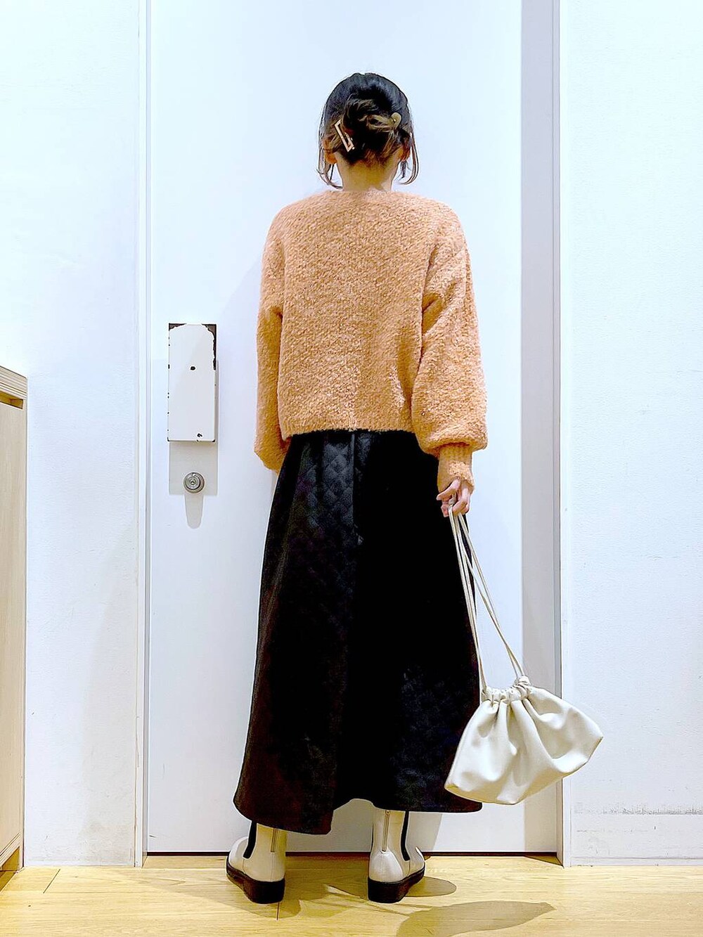 ベージュ系のブーツ、ベージュ系のショルダーバッグ、ブラック系のスカートを着用したレディースの冬コーディネートの5枚目の写真