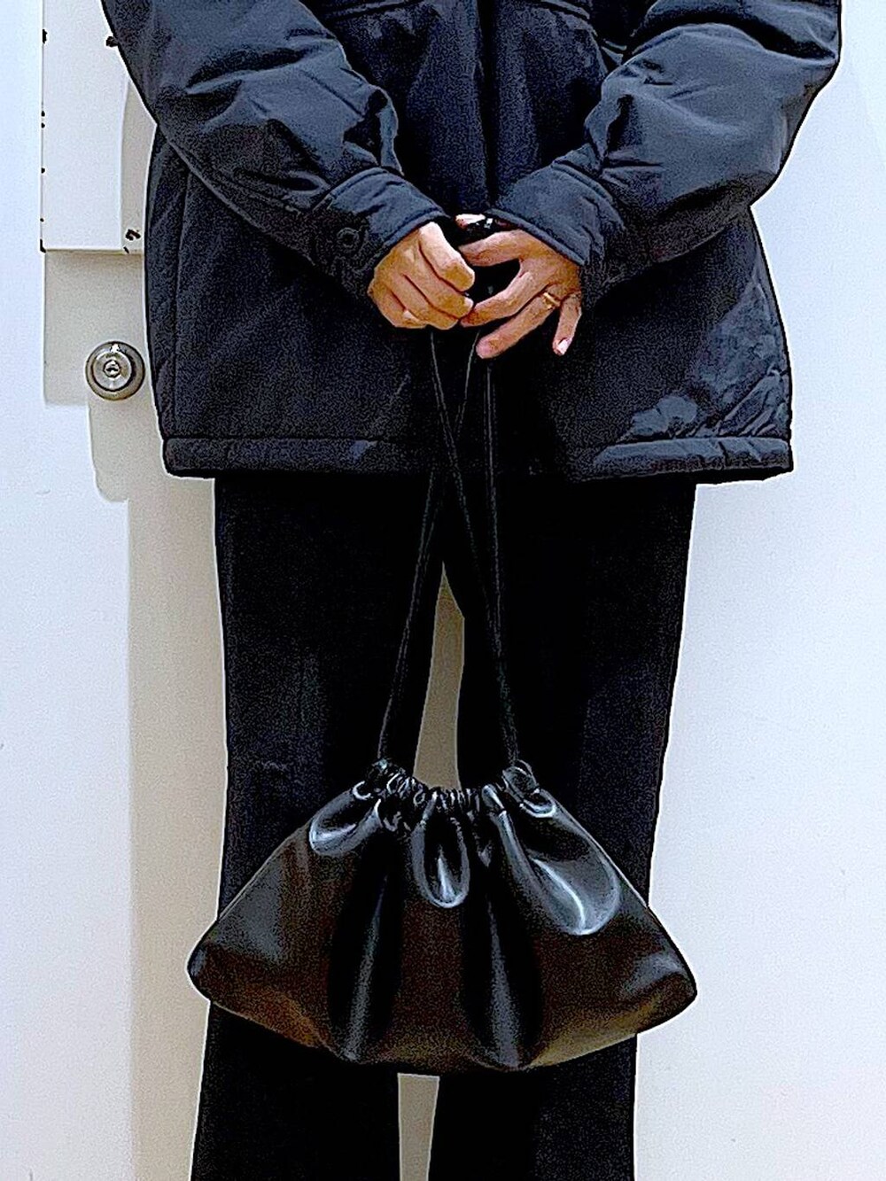 ブラック系のブルゾン、ブラック系のショルダーバッグ、ブラック系のブーツを着用したレディースの冬コーディネートの9枚目の写真