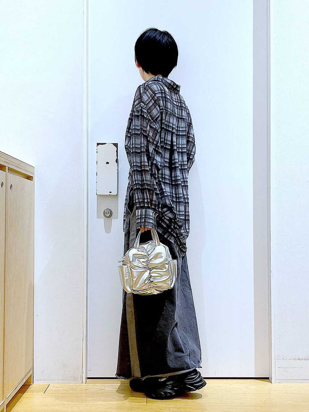 ブラック系のスニーカー、ブラック系のデニムスカート、グレー系のシャツ/ブラウスを着用したレディースの春コーディネートの3枚目の写真