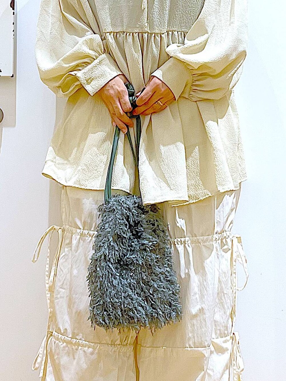 グリーン系のショルダーバッグ、ホワイト系のパンプス、ホワイト系のその他パンツを着用したレディースの秋コーディネートの9枚目の写真