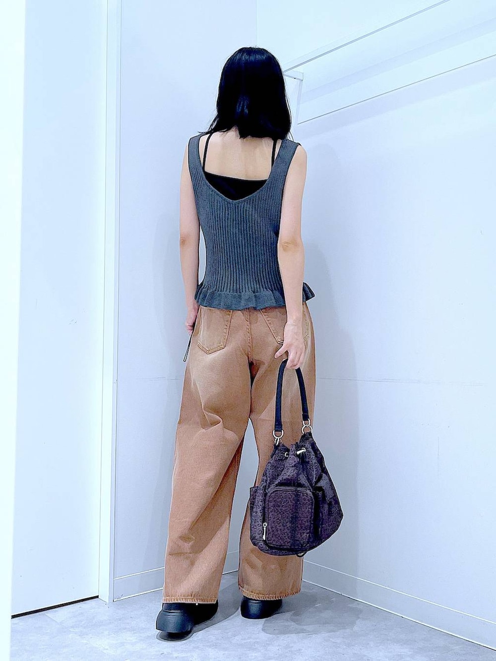 ブラウン系のデニムパンツ、グレー系のその他トップス、その他のハンドバッグを着用したレディースの夏コーディネートの5枚目の写真