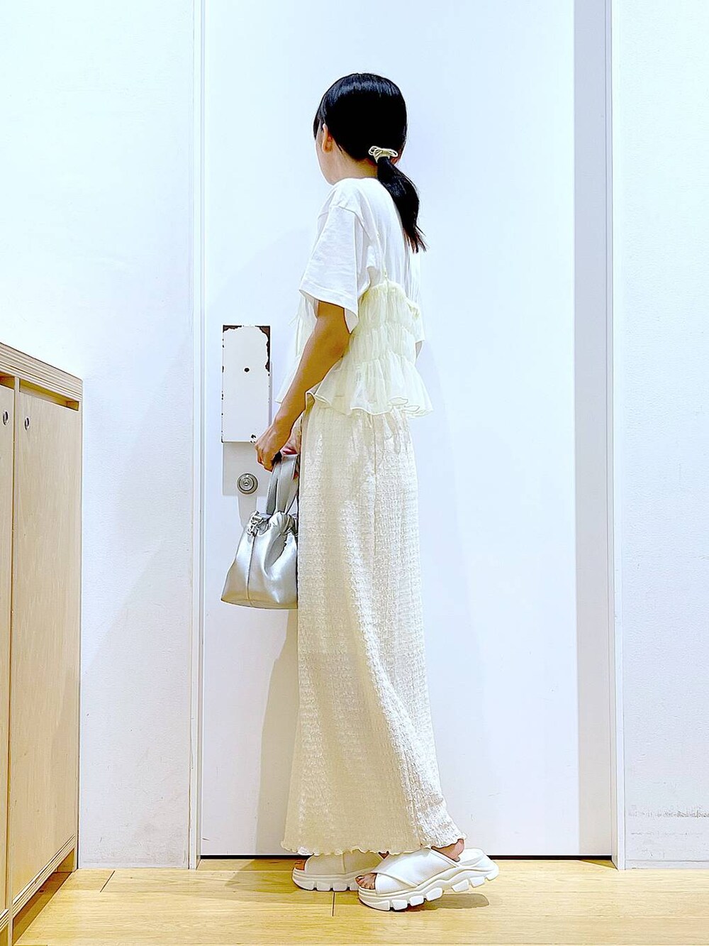 ホワイト系のサンダル、ホワイト系のTシャツ/カットソー、イエロー系のキャミソールを着用したレディースの夏コーディネートの3枚目の写真