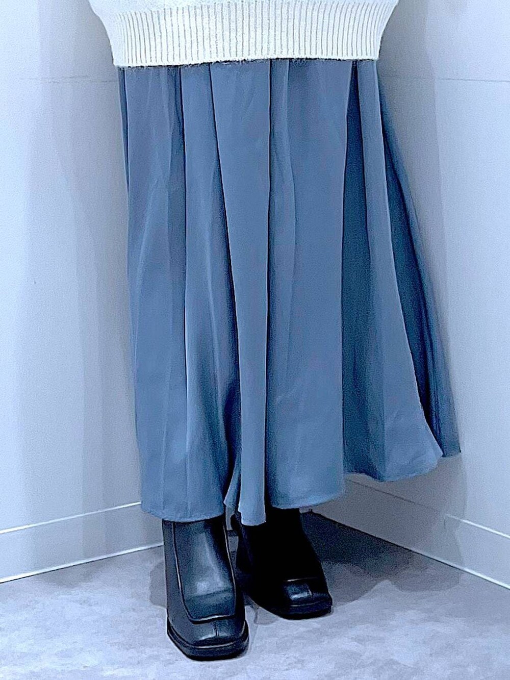 ブラック系のブーツ、ブルー系のスカート、ベージュ系のボストンバッグを着用したレディースの冬コーディネートの8枚目の写真